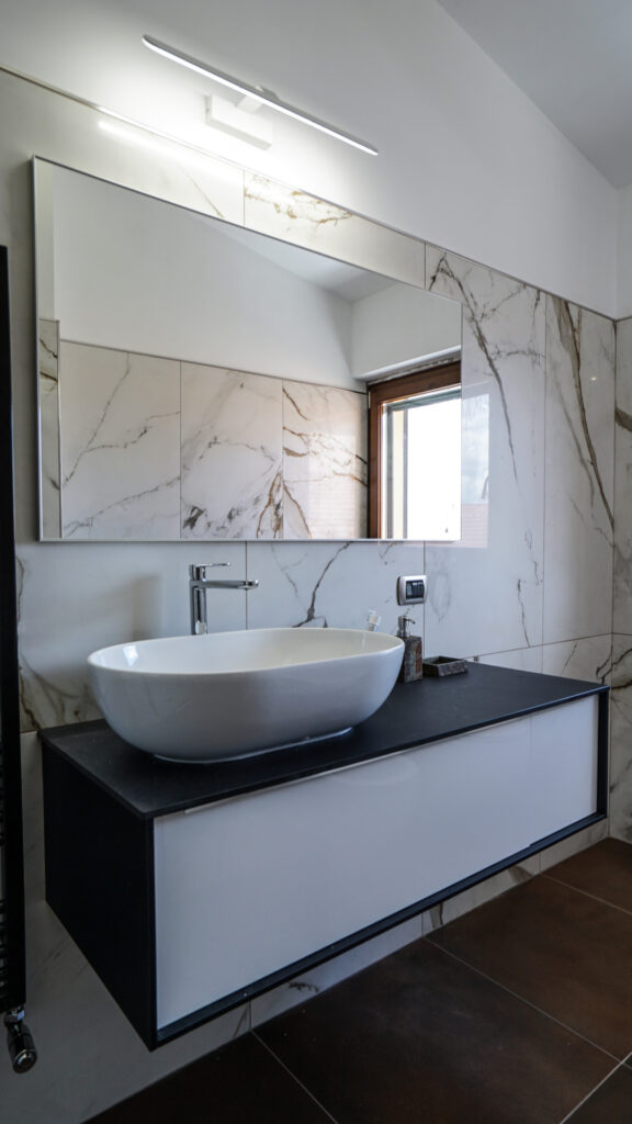 Bagno rivestito in grès effetto marmo e corten